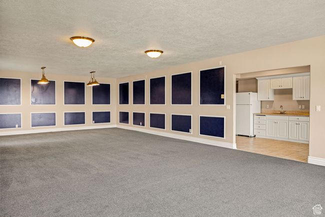 Unfurnished room with light carpet, a sink, a textured ceiling, and baseboards | Image 26
