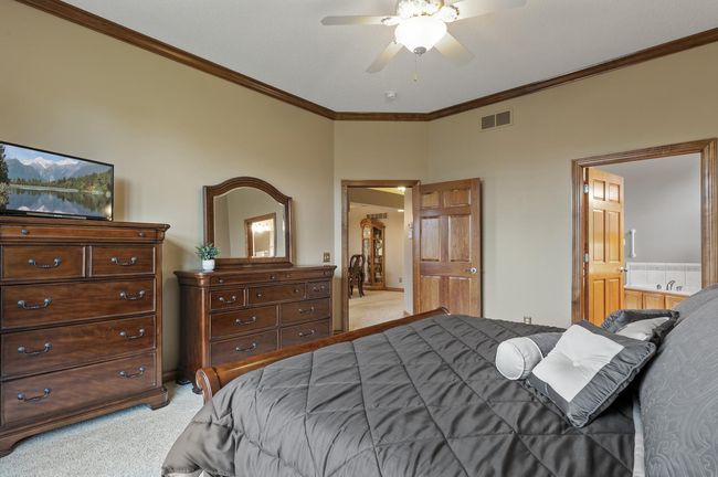 Primary bedroom on the main level is spacious and private. The neutral carpeting and walls will seamlessly work with your own personal décor. | Image 17