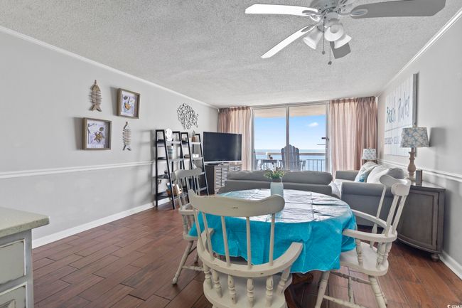 Dining room featuring crown molding, dark wood-type flooring, baseboards, floor to ceiling windows, and ceiling fan | Image 17