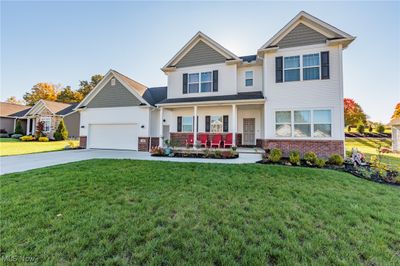 Craftsman-style home with a front yard, a porch, and a garage | Image 2