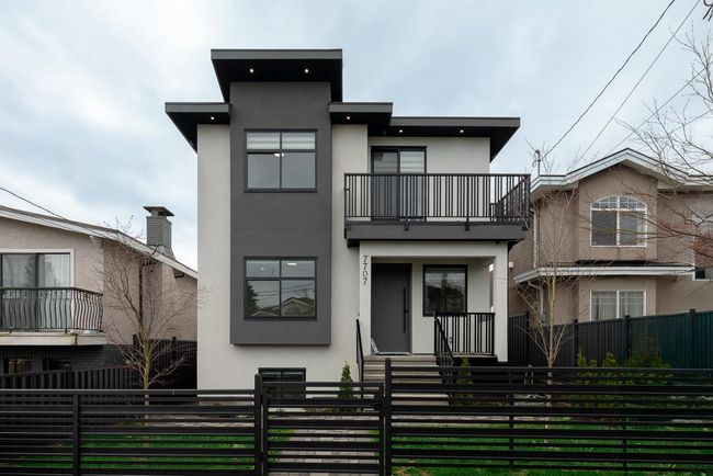 Rear view of house featuring a balcony, stucco siding, and a fenced front yard | Image 39