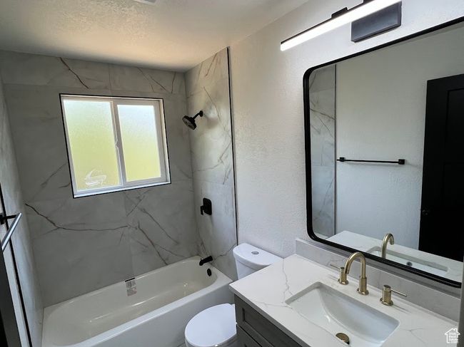 Full bath with vanity, shower combination, and a textured wall | Image 17