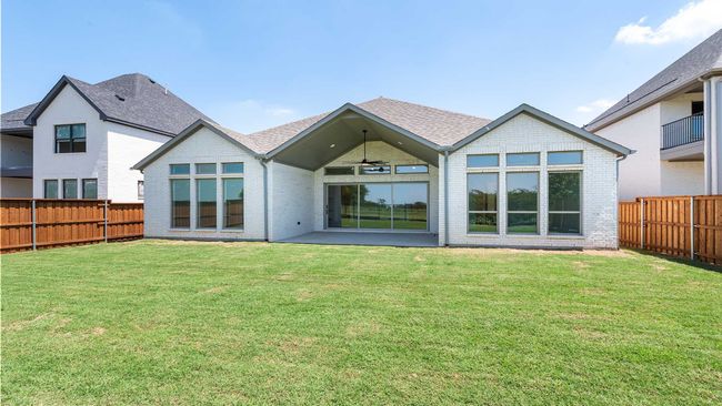 Rear view of property featuring brick siding, ceiling fan, a fenced backyard, and a yard | Image 20