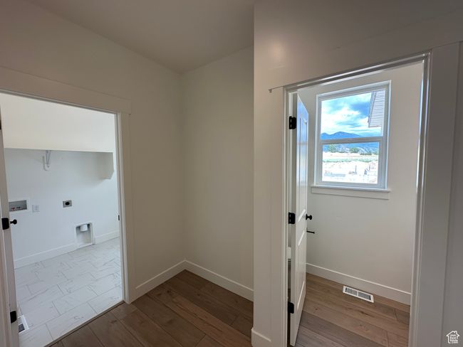 Laundry area with electric dryer hookup and wood finished floors | Image 11