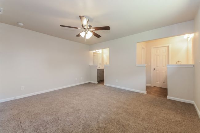 Unfurnished bedroom featuring carpet floors, ensuite bathroom, and ceiling fan | Image 17