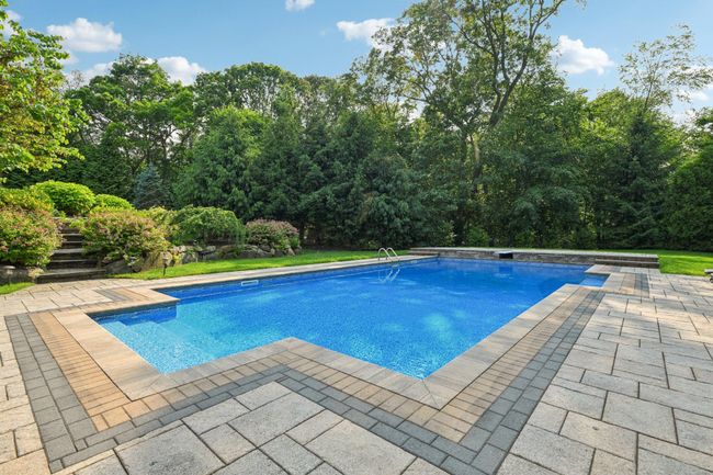 Swimming pool with a patio area and beautifully Landscaped Backyard with Lovely colorful plantings | Image 39