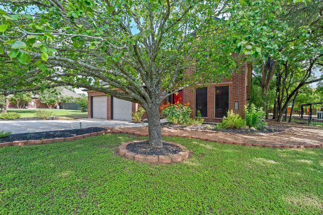 Obstructed view of property featuring a garage, driveway, and brick siding | Image 34