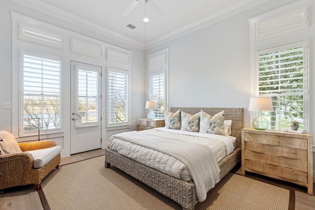 Bedroom featuring light wood finished floors, multiple windows, visible vents, and ornamental molding | Image 15