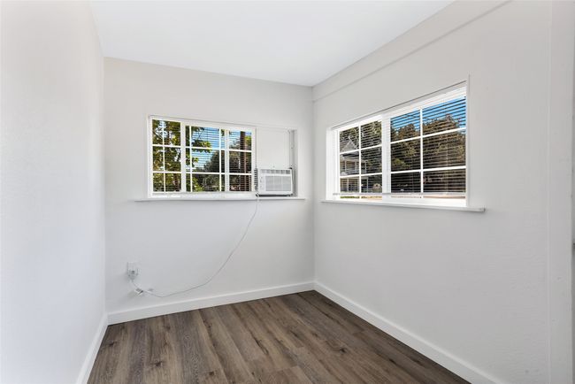Empty room featuring healthy amount of natural light, dark wood-style floors, and cooling unit | Image 9