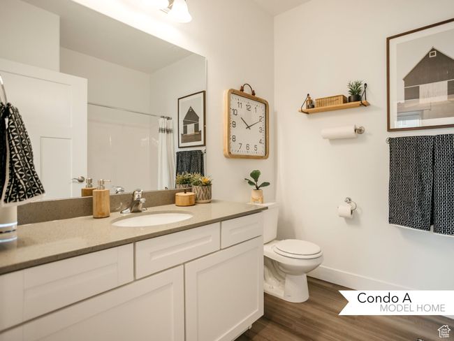 Full bath with baseboards, a shower with shower curtain, toilet, vanity, and wood finished floors | Image 12