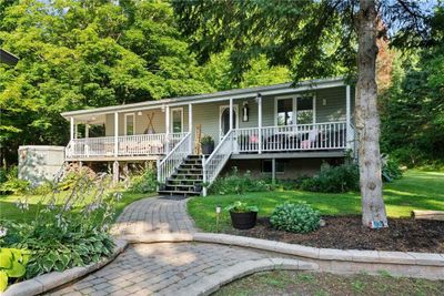 Charming bungalow with serene front porch views. | Image 1