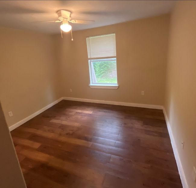 Spare room with baseboards, a ceiling fan, and dark wood-type flooring | Image 7