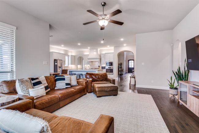 Living area featuring a ceiling fan, a tile fireplace, and dark wood-style floors | Image 6
