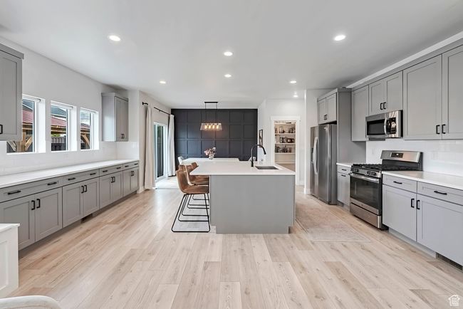 Kitchen with appliances with stainless steel finishes, a sink, gray cabinetry, light countertops, and recessed lighting | Image 6
