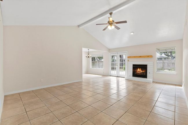 The wood-burning fireplace adds a cozy touch, perfect for relaxing nights in or entertaining guests in this airy, light-filled living space | Image 4