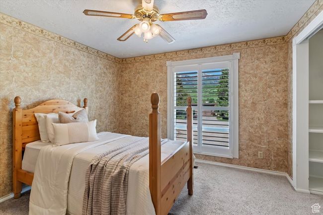 Bedroom with carpet, baseboards, a textured ceiling, and a ceiling fan | Image 20