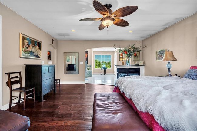 Bedroom featuring arched walkways, wood finished floors, recessed lighting, and baseboards | Image 19