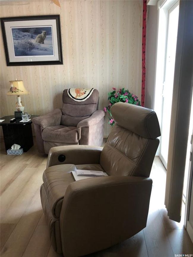 Sitting room with plenty of natural light, wallpapered walls, and wood finished floors | Image 26