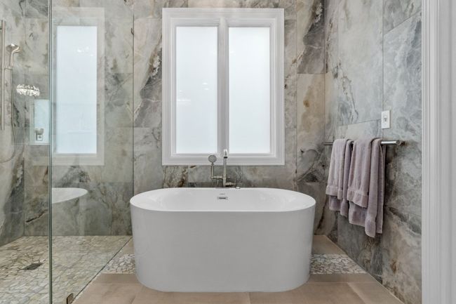 Enjoy a soak in the main-level primary bedroom, complete with privacy windows. | Image 16