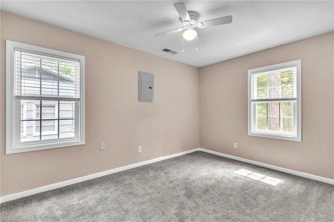 Carpeted spare room with baseboards, electric panel, visible vents, and plenty of natural light | Image 35