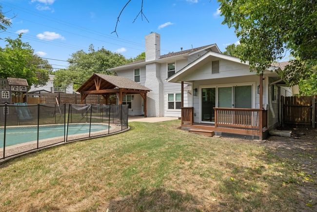 Back of house featuring fence, a fenced in pool, a chimney, and a gazebo | Image 33