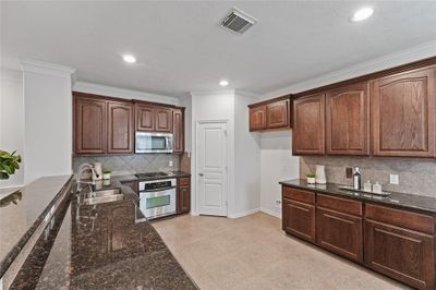 This kitchen is a great size and features granite countertops, stainless steel appliances, walk-in pantry, and amply storage space. | Image 3