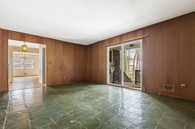 Unfurnished room featuring wooden walls, visible vents, and a chandelier | Image 15