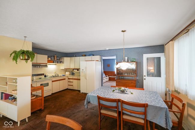dining space with dark carpet and wallpapered walls | Image 14