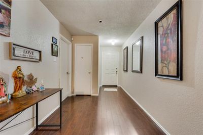 Hall featuring dark hardwood / wood-style floors and a textured ceiling | Image 2