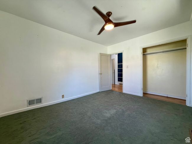 Unfurnished bedroom featuring carpet, baseboards, a closet, and a ceiling fan | Image 21