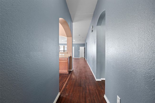 Hallway featuring dark wood-type flooring, arched walkways, and a textured wall | Image 26