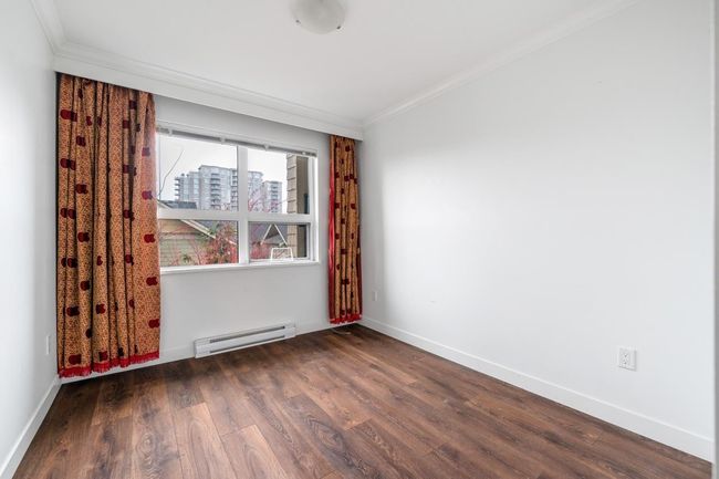 Unfurnished room featuring baseboard heating, crown molding, and wood finished floors | Image 19