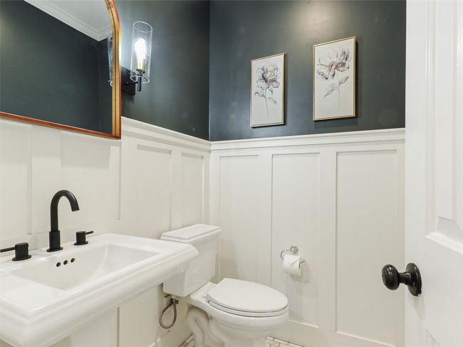 Bathroom featuring wainscoting, toilet, a sink, and a decorative wall | Image 13