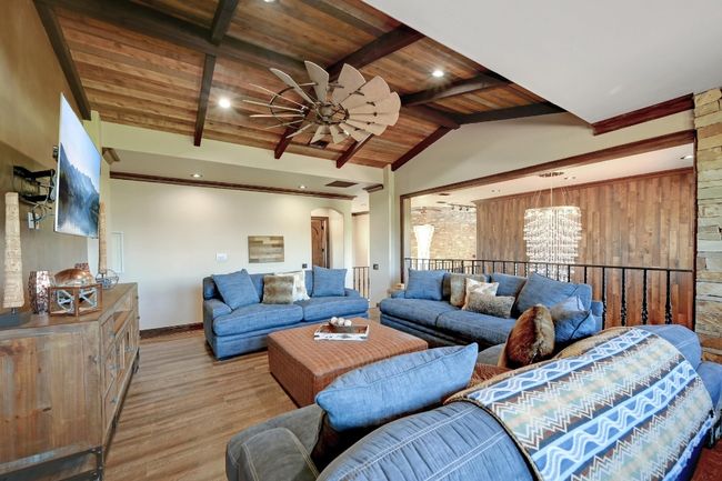 Living area with baseboards, wood ceiling, vaulted ceiling with beams, ceiling fan with notable chandelier, and wood finished floors | Image 30