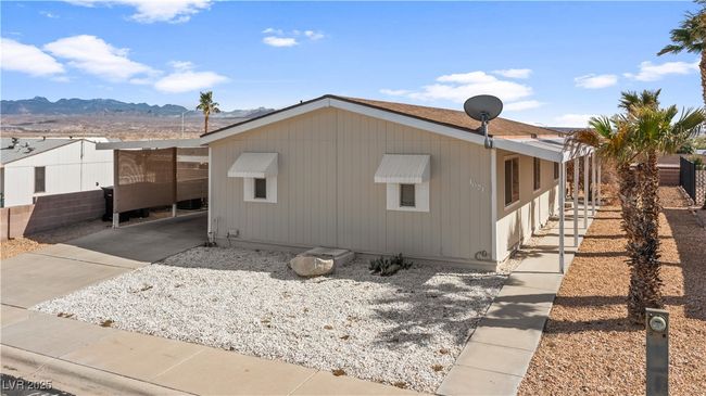 View of side of property featuring a mountain view, an attached carport, and concrete driveway | Image 60