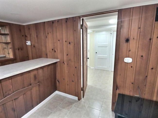 Bar area with wooden walls and baseboards | Image 32