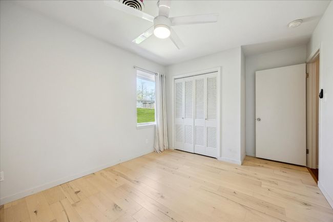 Unfurnished bedroom with a closet, baseboards, visible vents, and wood finished floors | Image 19