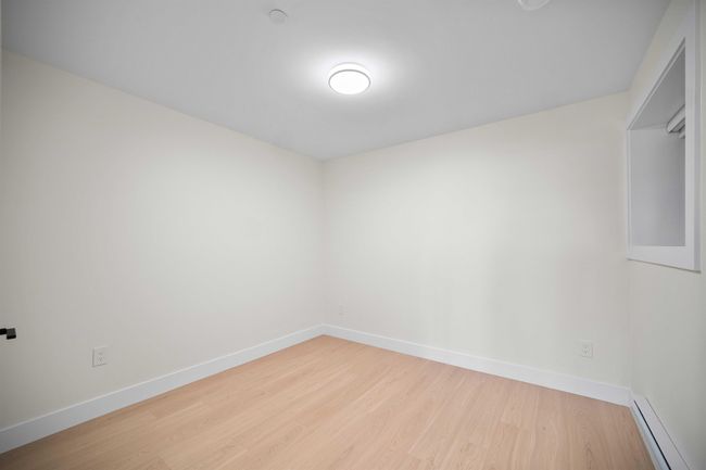 Empty room featuring baseboard heating and wood finished floors | Image 23