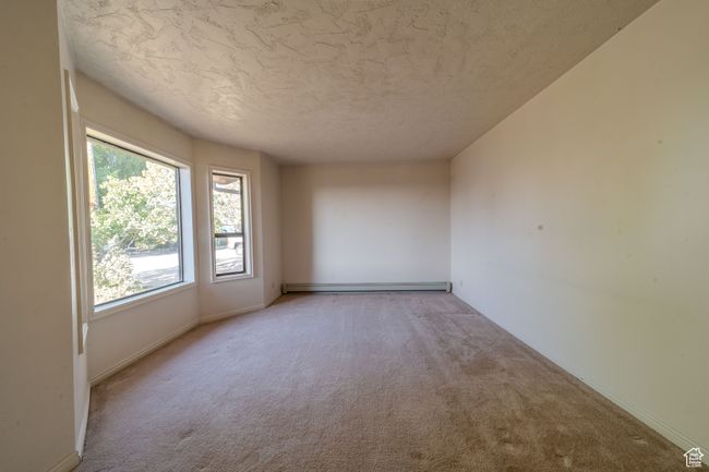 Formal room with baseboards, baseboard heating, carpet flooring, and a textured ceiling | Image 11