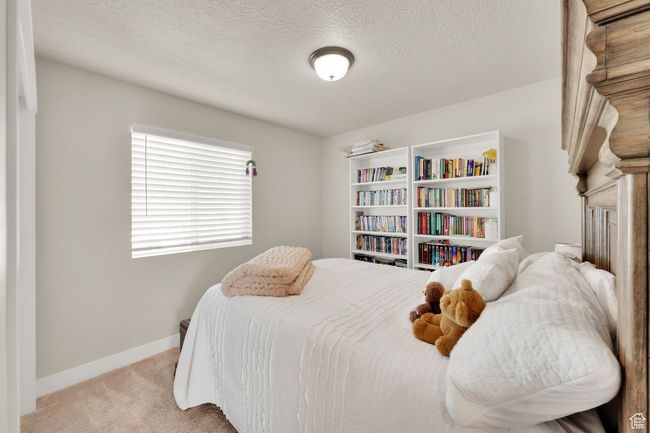 Bedroom with light carpet, baseboards, and a textured ceiling | Image 24