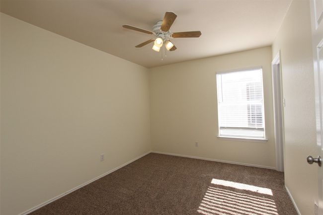 Carpeted spare room featuring a ceiling fan and baseboards | Image 18