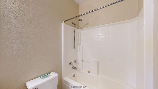 Full bath featuring toilet, shower / tub combination, and a textured wall | Image 22