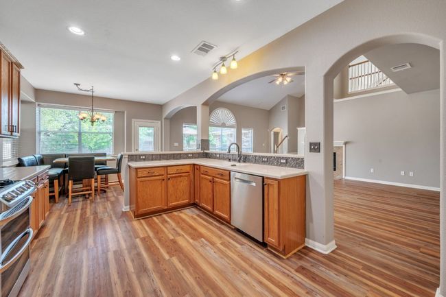 Kitchen with light wood-style flooring, visible vents, and appliances with stainless steel finishes | Image 15