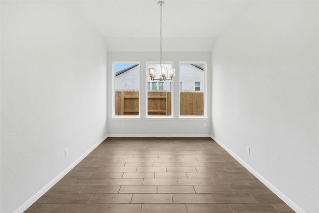 Unfurnished dining area with a chandelier, baseboards, and dark wood-style floors | Image 4