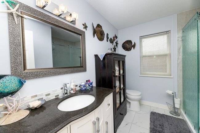Full bath with baseboards, toilet, marble finish floor, vanity, and a shower stall | Image 16