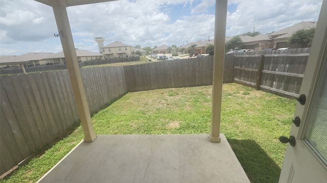 Fenced backyard with a residential view and a patio area | Image 6