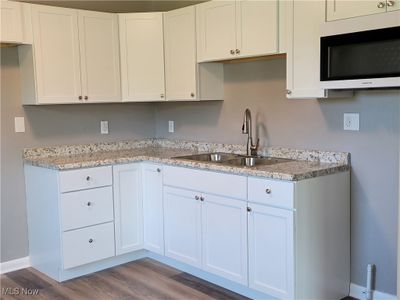 Kitchen featuring sink, hardwood / wood-style floors, and white cabinetry | Image 3