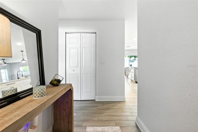 This bright entryway welcomes you with wood-look tile and a peek into the heart of the home | Image 6