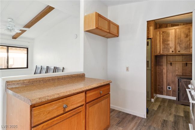Kitchen with ceiling fan, lofted ceiling with beams, baseboards, light countertops, and wood style floors | Image 13