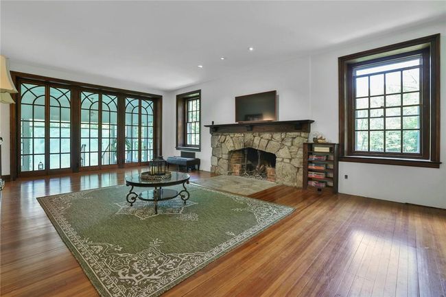 10' ceilings, crown moldings, custom millwork, stone-clad fireplace and hearth topped by a generous 10' mantel | Image 7